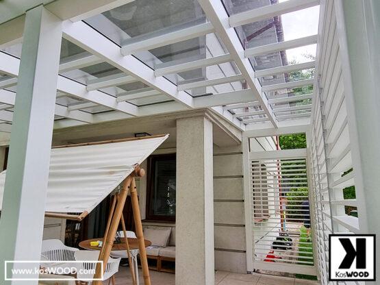 Białe zadaszenie tarasu z żaluzjami typu shutters