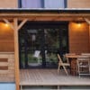 Zadaszenie tarasu zabudowane ruchomymi żaluzjami i drewnianą balustradą.