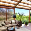 Zadaszenia tarasu z regulowanymi żaluzjami shutters i poliwęglanowym pokryciem dachu fastlock nad eleganckim zestawem wypoczynkowym
