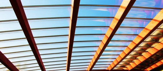 Drewniane zadaszenie tarasu z żaluzjami regulowanymi i przezroczystym dachem z poliwęglanu fastlock