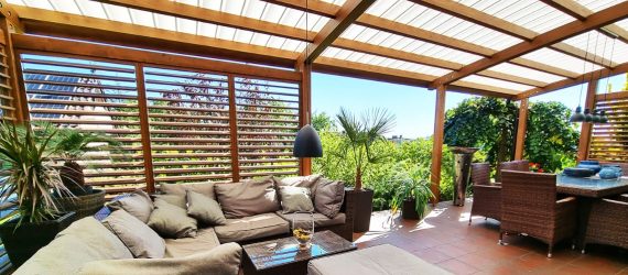 Zadaszenia tarasu z regulowanymi żaluzjami shutters i poliwęglanowym pokryciem dachu fastlock nad eleganckim zestawem wypoczynkowym